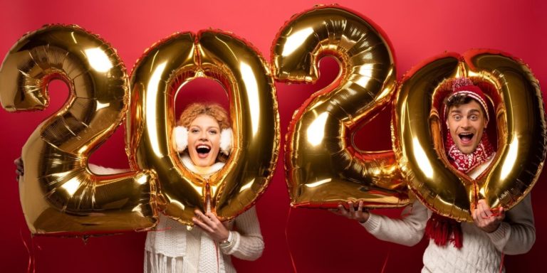 Two people celebrating the New Year with gold balloons in the shape of 2020. Could they be celebrating with a New Job?