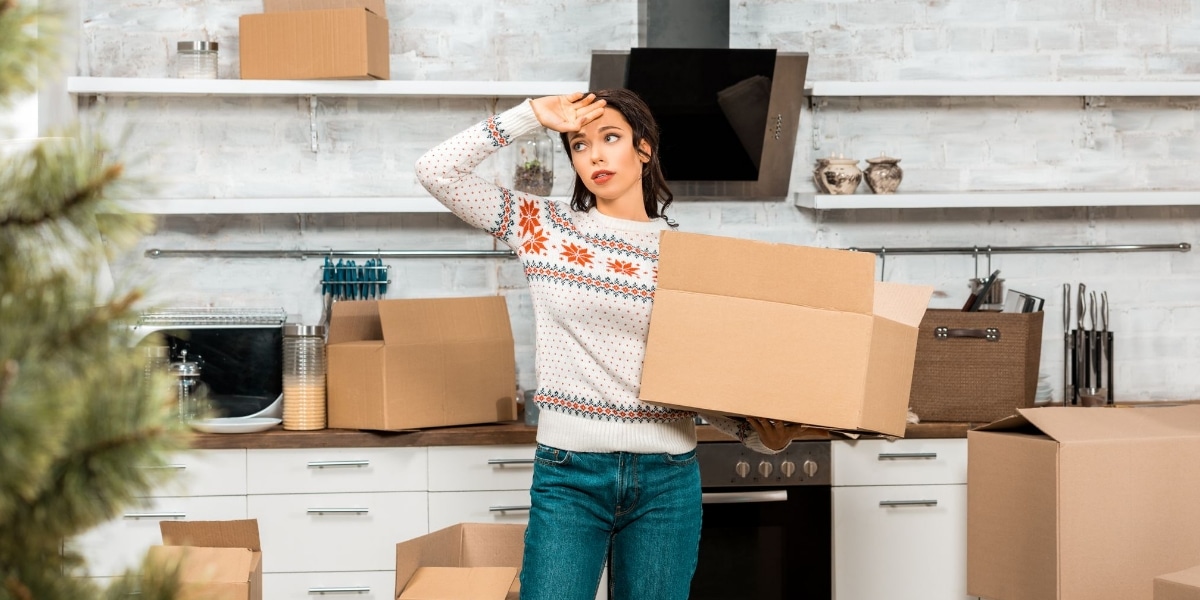 Lady looking worried after packing her stuff for her relocation up North