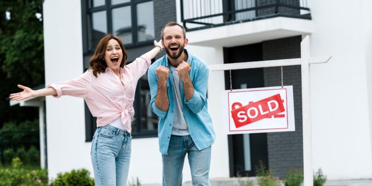 a woman and a man are euphoric after finalising the purchase of their new home