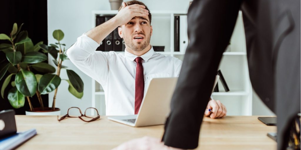 Employer covering his face looking very worried about the prospect of Blue Monday