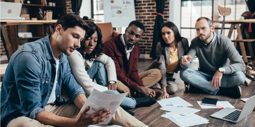 A team of people sitting on the floor of a modern office