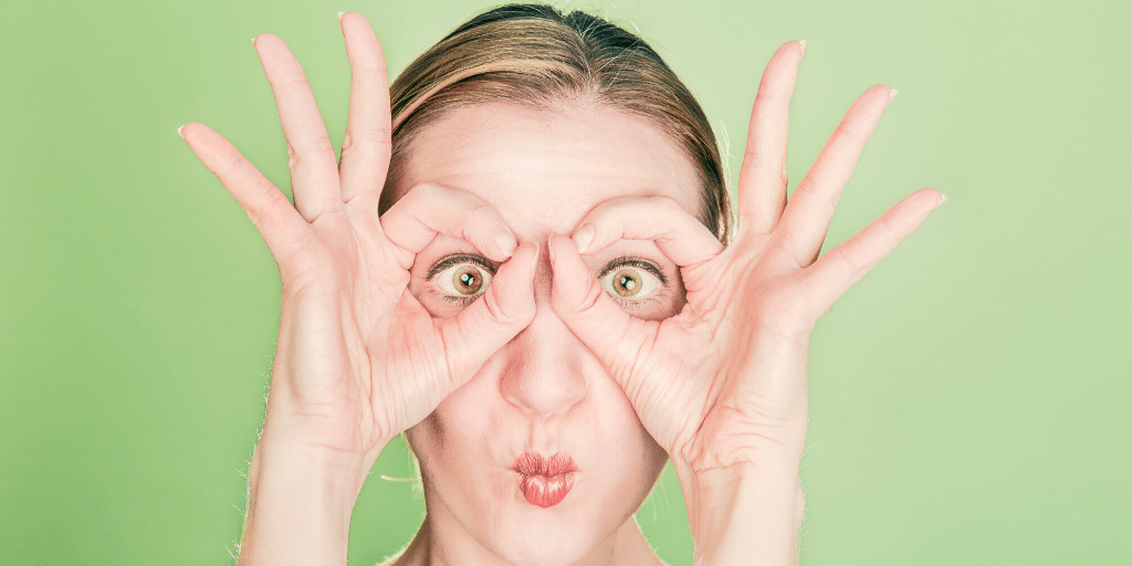 Lady making a silly face and using her hands like binoculars to search for IT talent