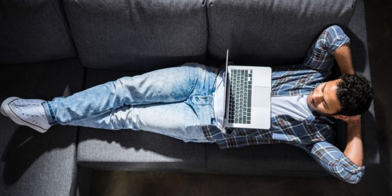 Man relaxing on the sofa with his laptop