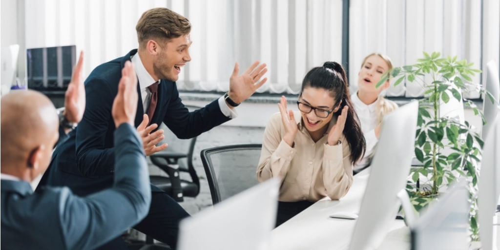 Office workers celebrate their colleagues success despite the crisis