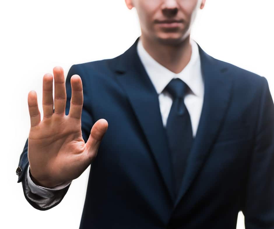 Man in a suit holding his hand up as if to refuse a request