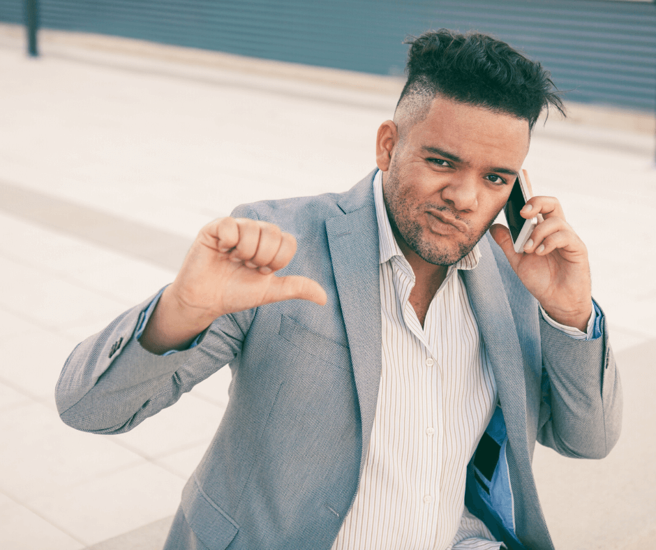 Man on the phone giving the thumbs down to a bad recruiter