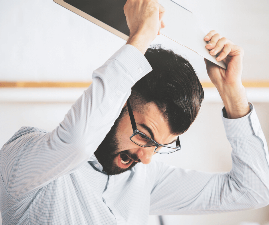 Man venting frustration at his laptop