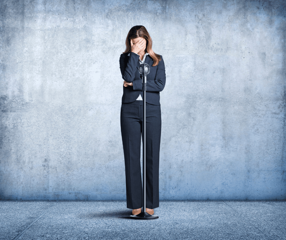 Lady stands in front of microphone hiding her face