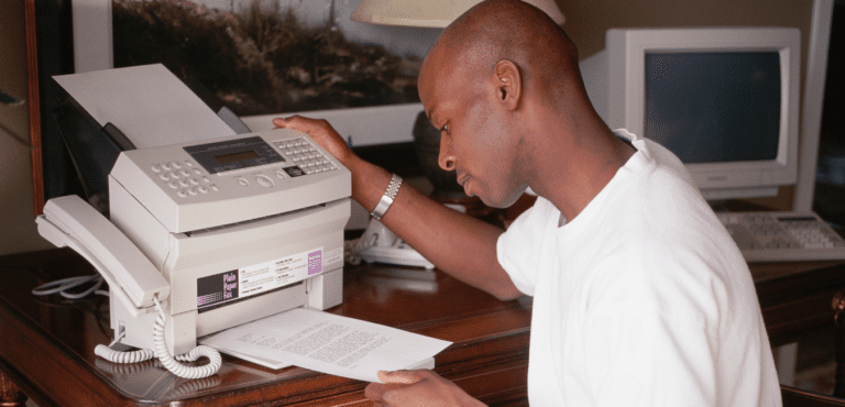 Man operating a fax machine, the ultimate recruitment technology in the 1990s