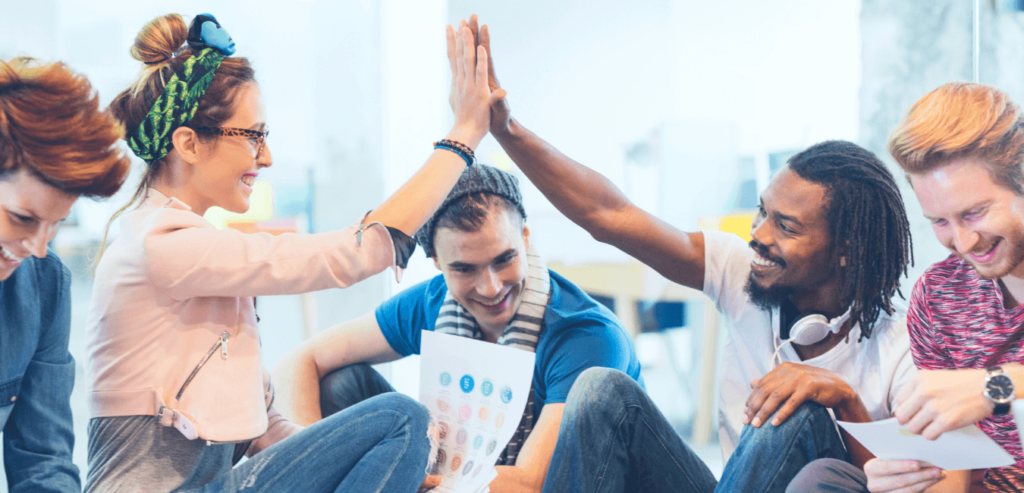 Digital agency team mates hi-five each other