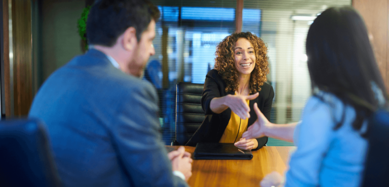 Interviewer showing signs you will get the job after interview with her smile and welcoming handshake