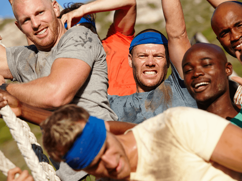 Lots of sweaty, muddy men on a physical bootcamp