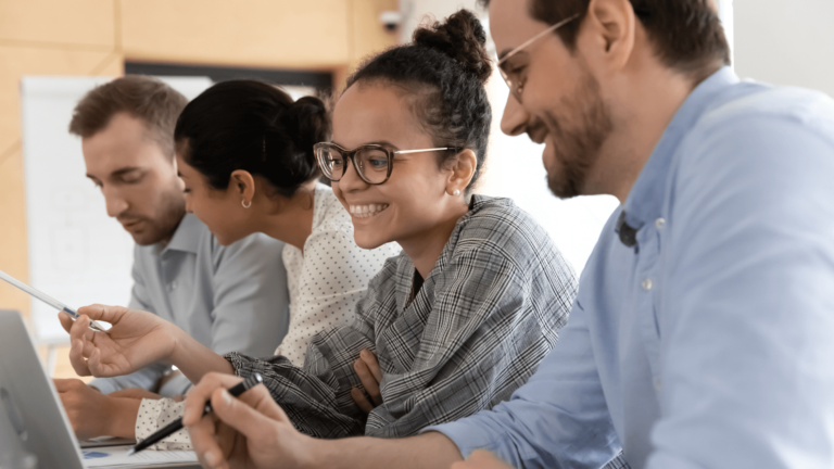 Four happy employees working at their desk