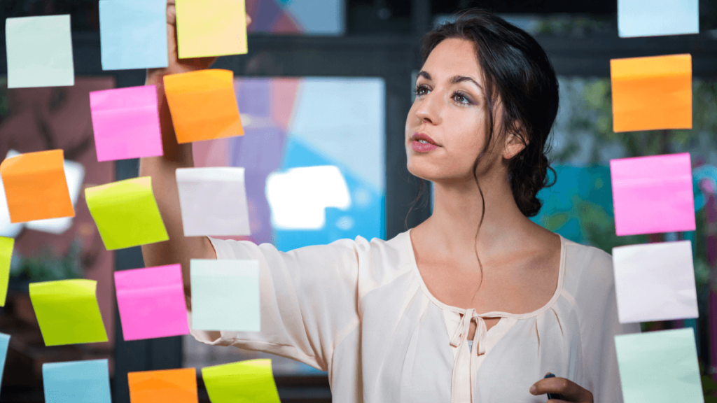 Lady writing sticky notes on an office window