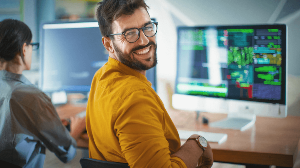 Man grins from his computer desk, does he have a degree or work experience? He has both