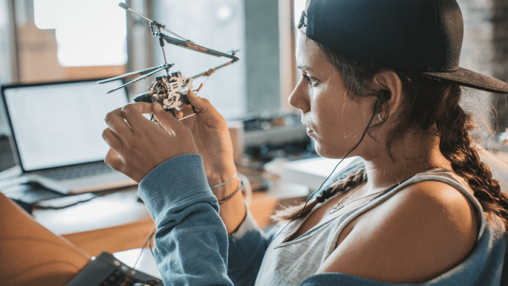 Young lady makes a model helicopter robot