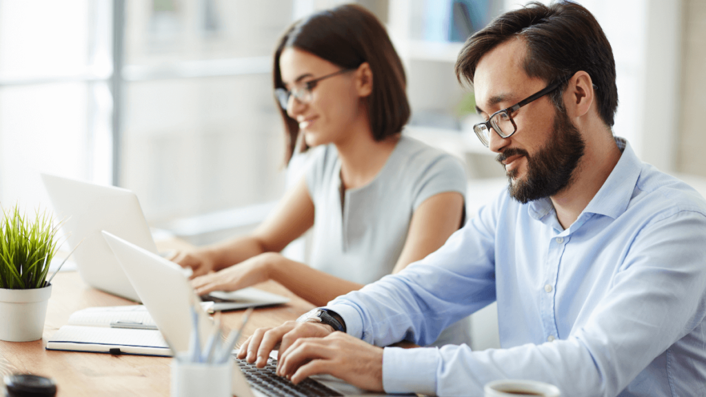 Two IT workers sit side by side, one is a contractor, the other employed by the company but they're doing the same job