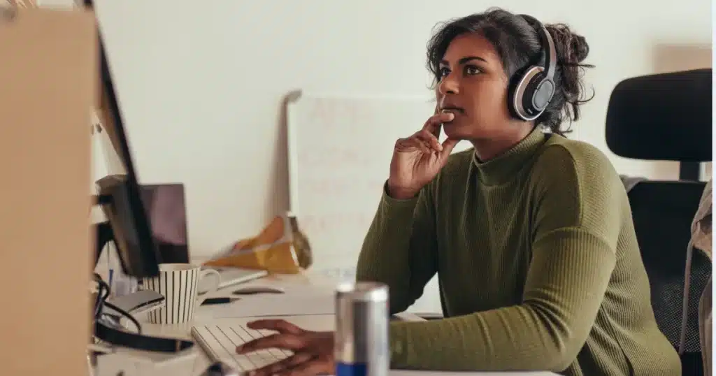 A woman looks worried while working in tech