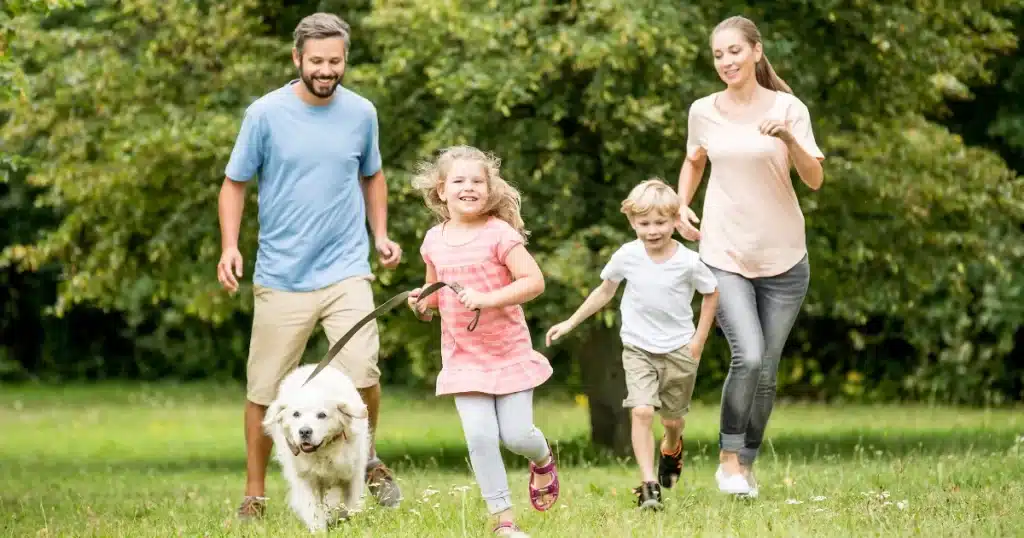 A family disconnects after work to avoid burnout playing with the kids and the dog in the outdoors