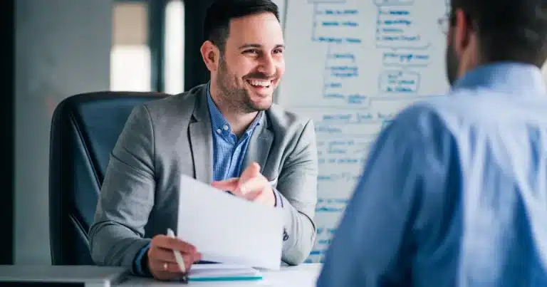 A male recruitment consultant talks amicably with a candidate about his personal goals and career ambitions