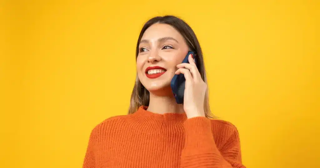 A young woman smiles while acing her pre screening interview with a recruiter