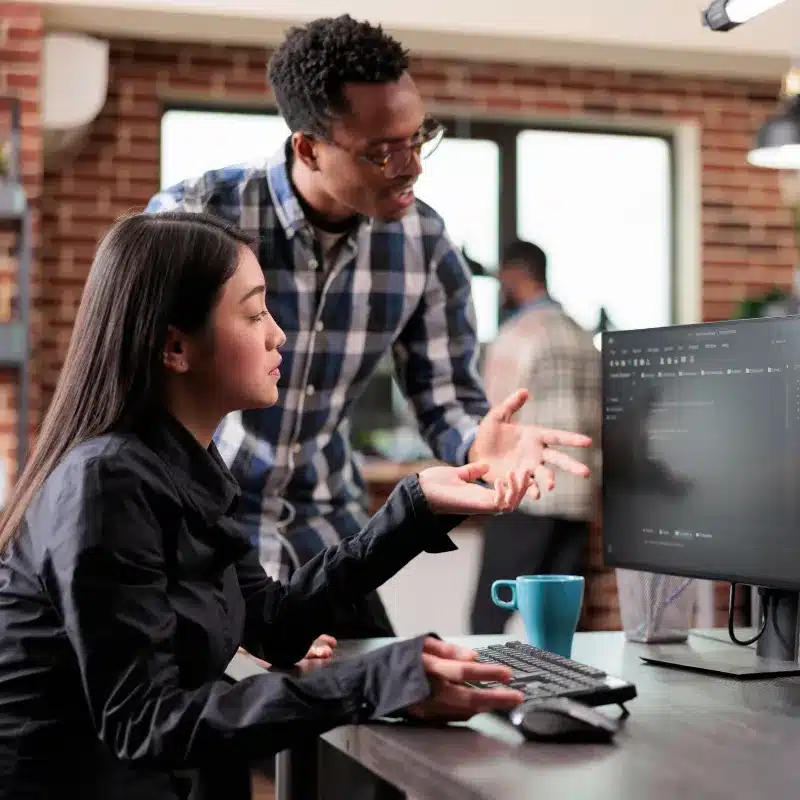 A black man and an asian woman discuss about the technical aspects of a project