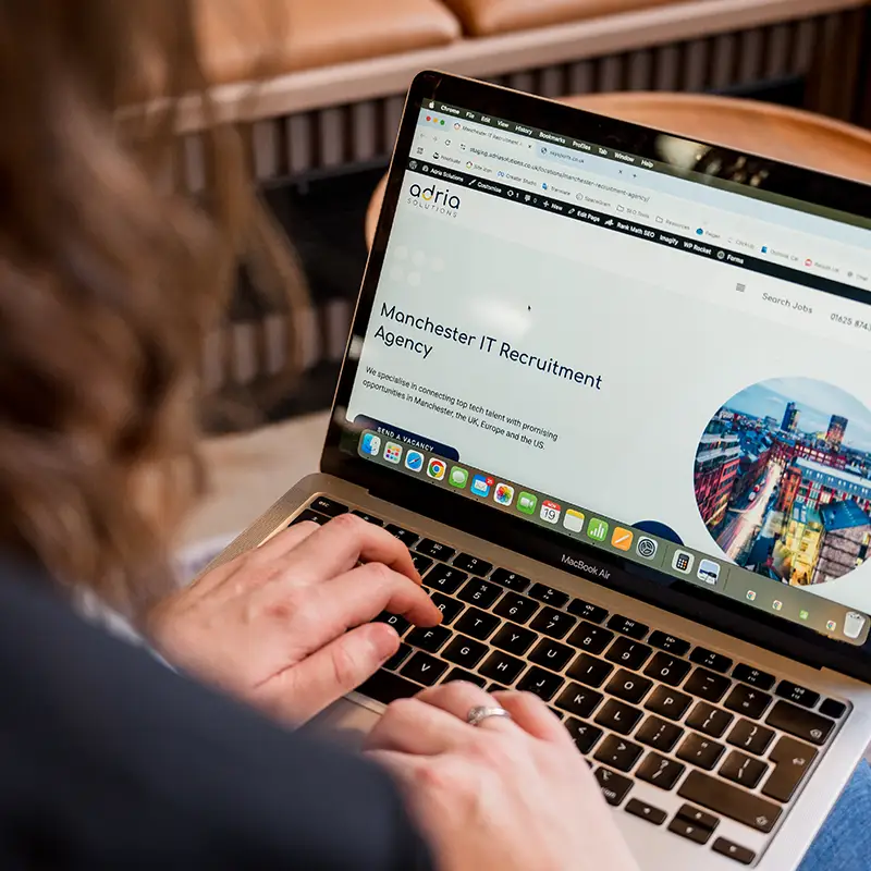 A woman browses the Adria Solutions website in her laptop